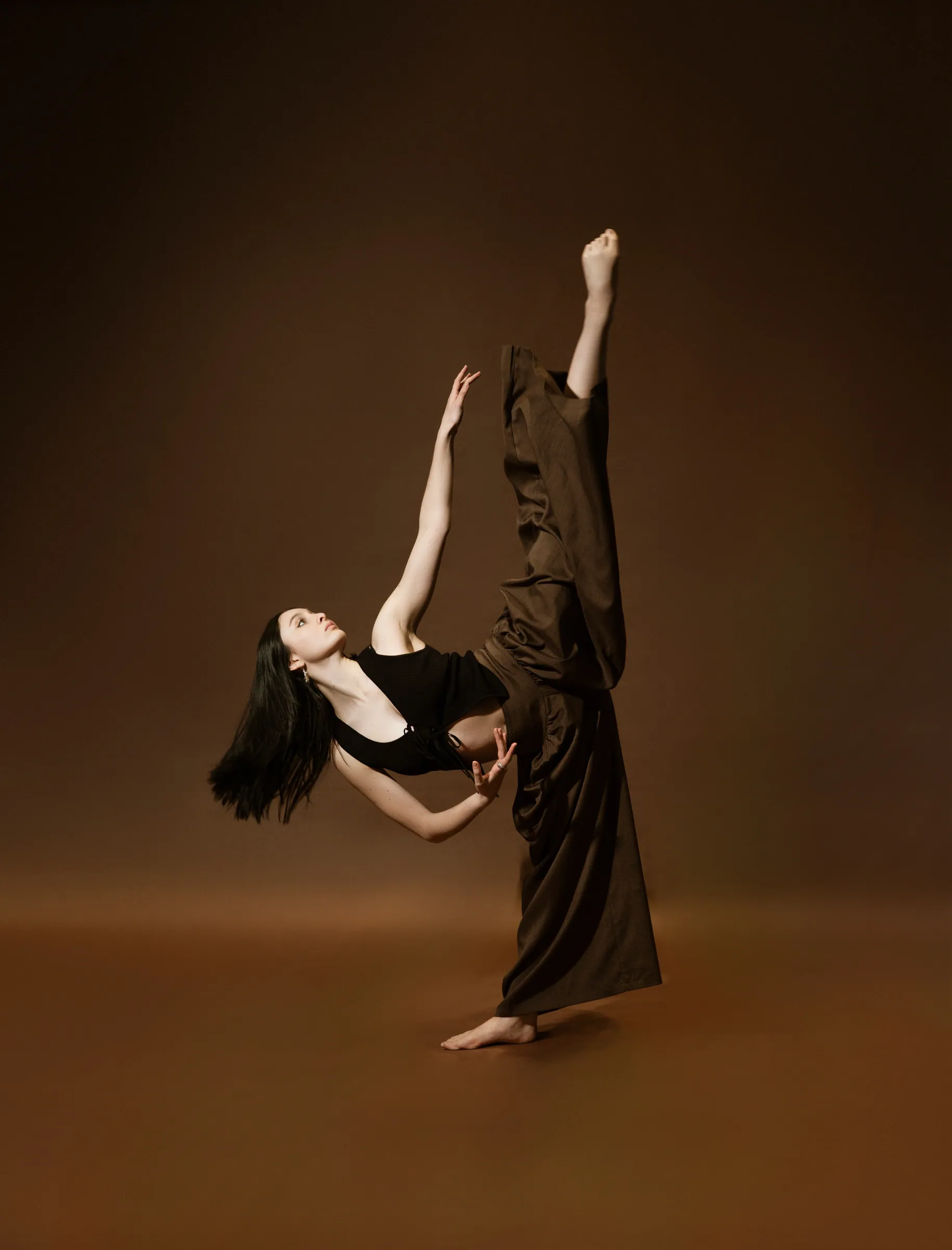 Estefania Forero Yacaman balancing in a warm brown studio portrait