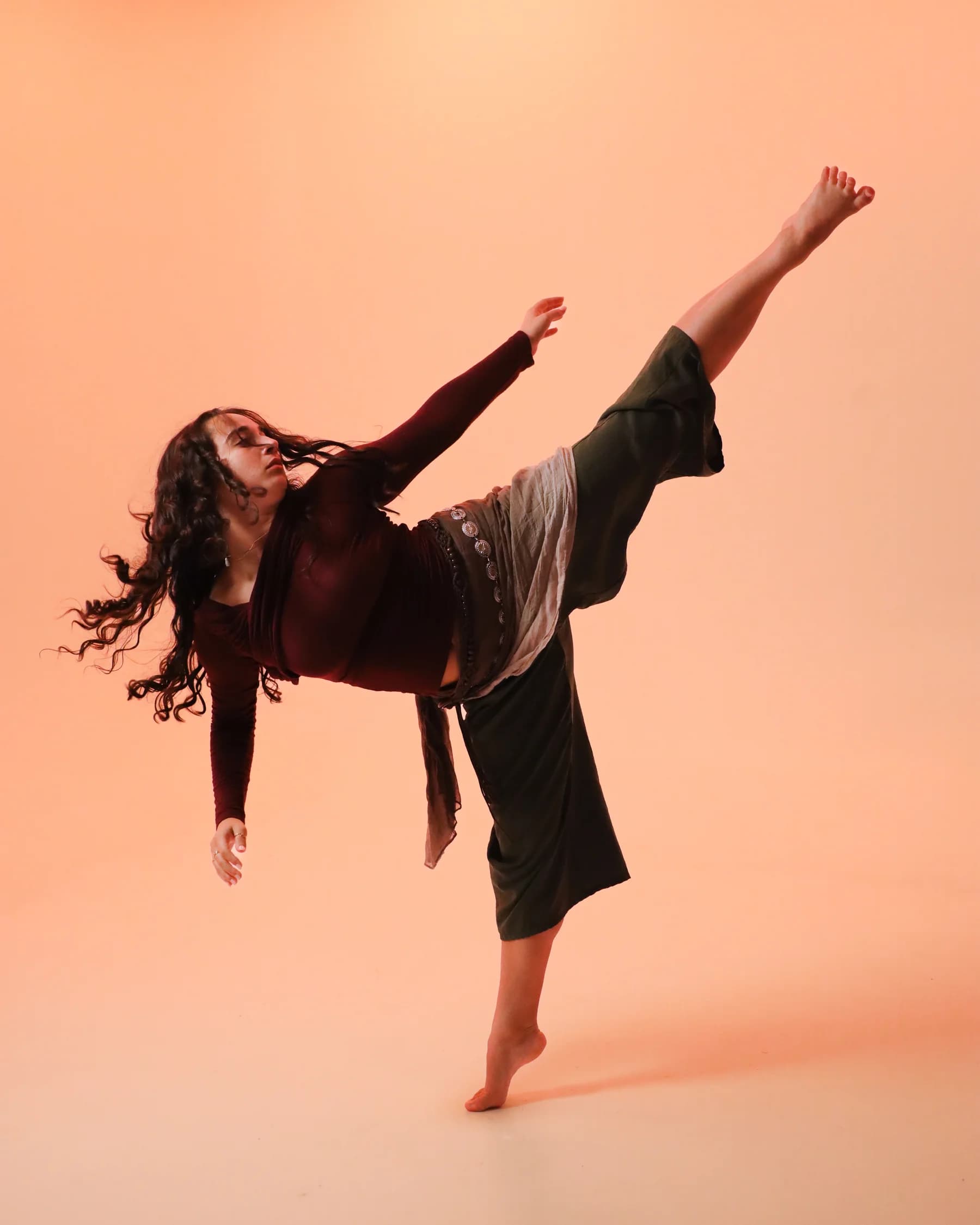 A dancer balancing on one leg with the other extended high behind her