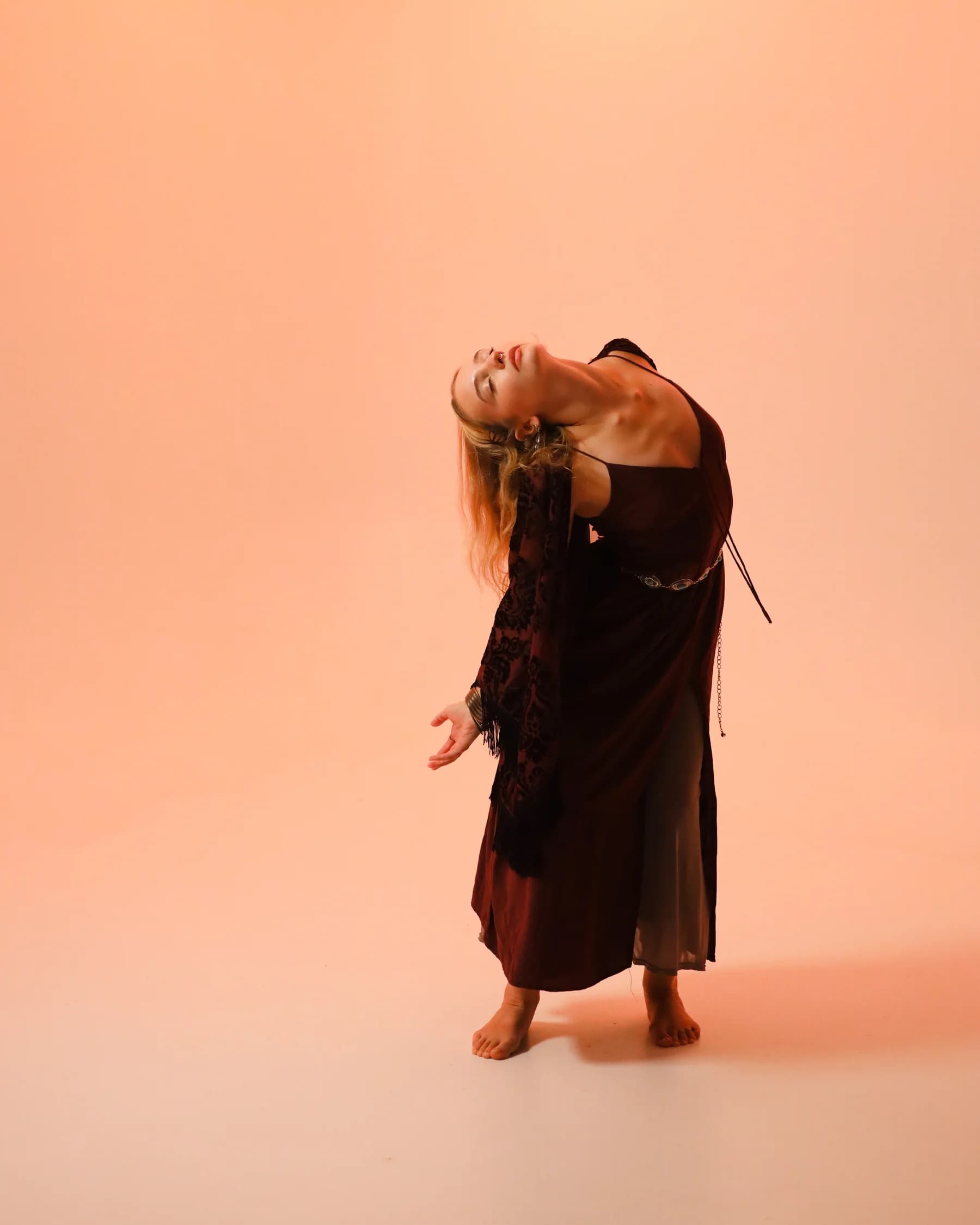 A dancer folding forward with loose hair and softly curved arms