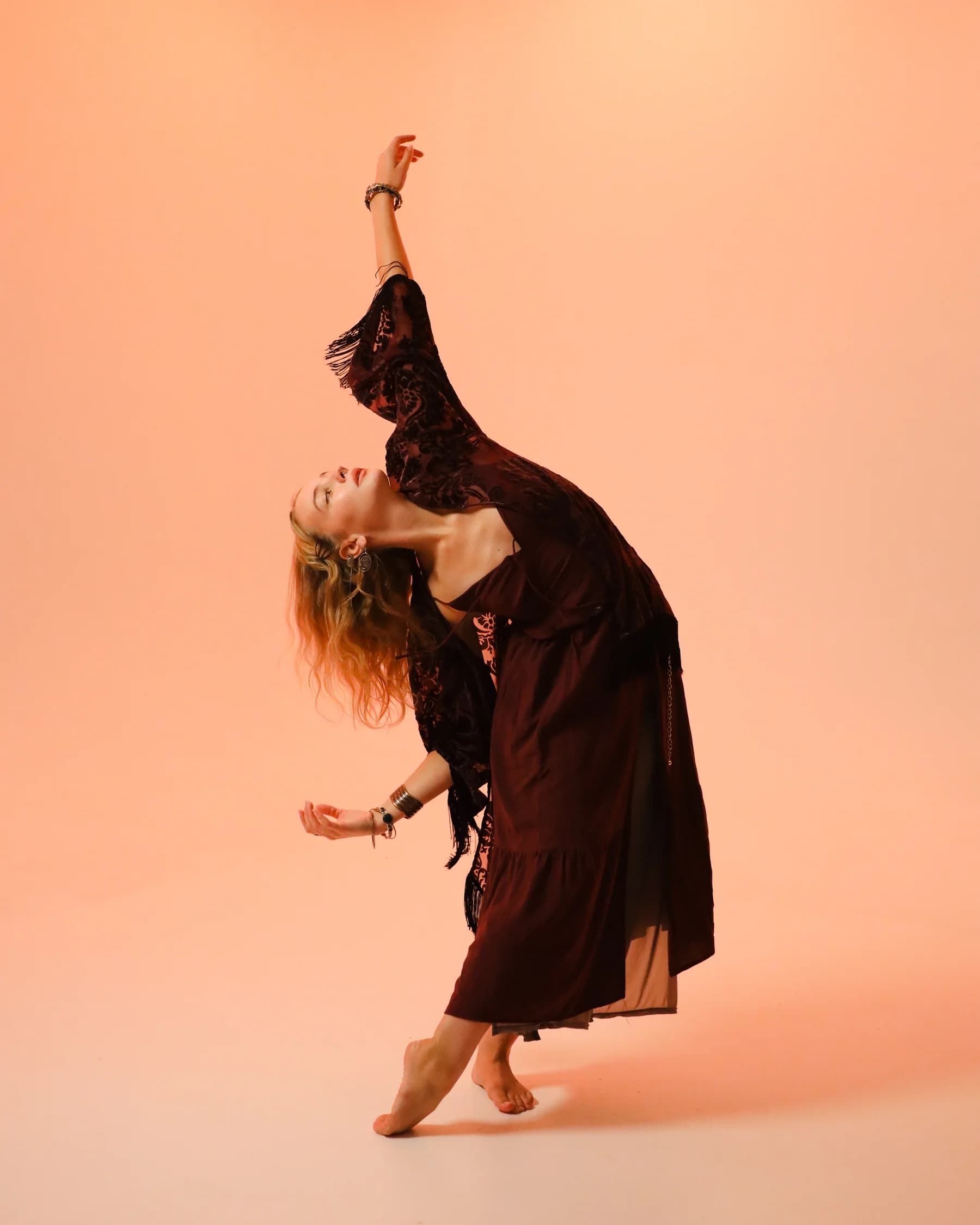 A dancer reaching one arm overhead through a deep side bend